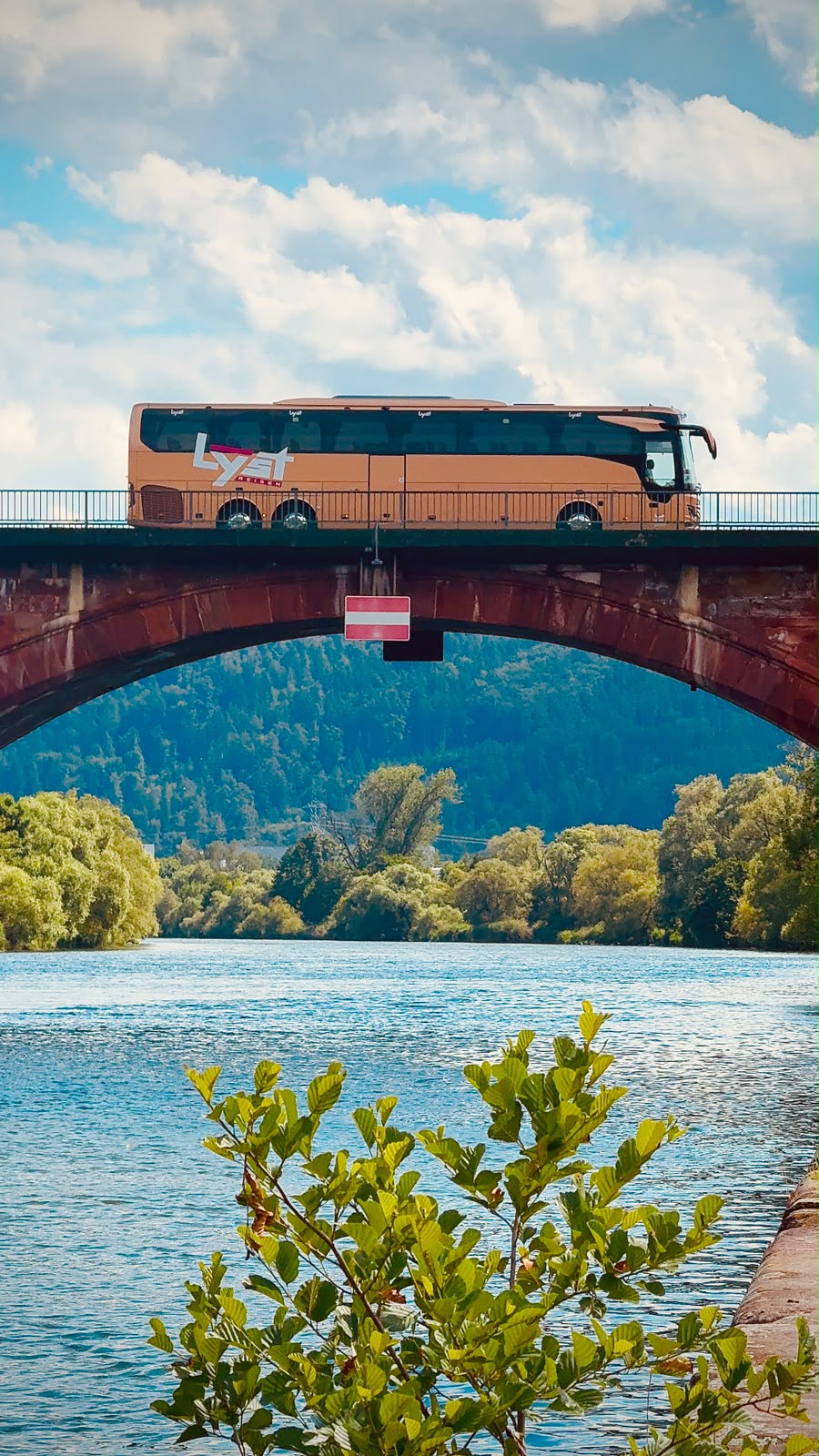 Our coach crossing a stone arch bridge over the river on the way to Switzerland