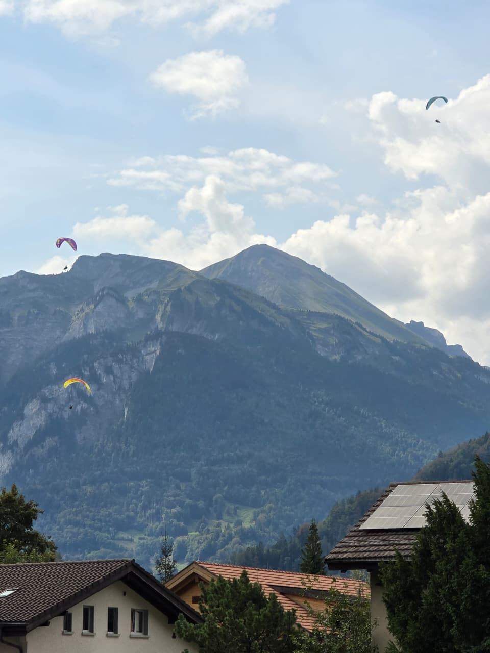 Paragliders floating over the mountains above Interlaken