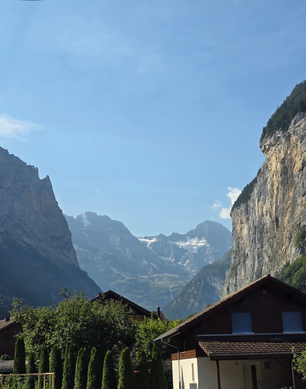 Glacier framed between the cliffs of Lauterbrunnen above wooden chalets